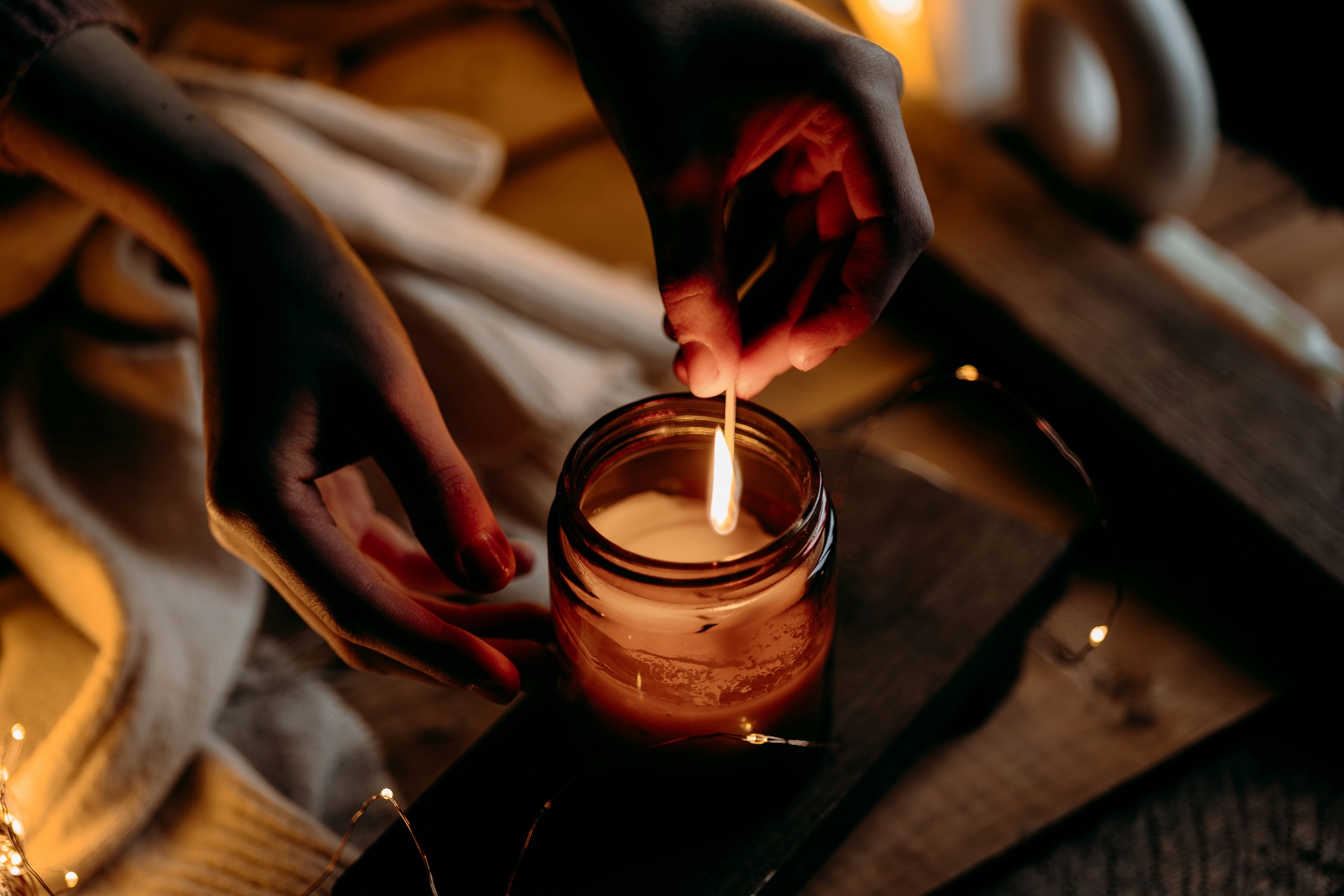 A single candle in a glass vessel glowing in low light