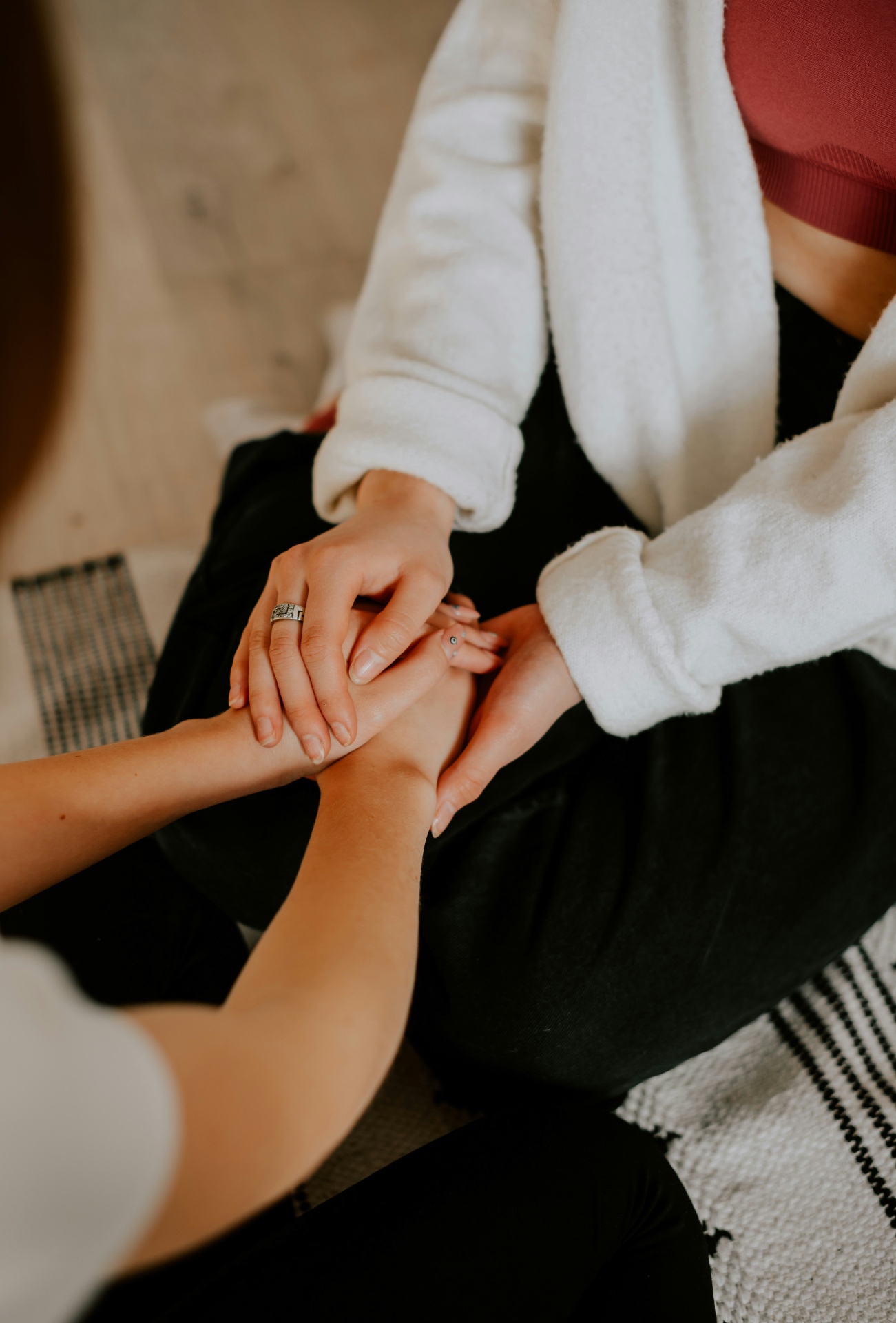 Two hands resting gently together in soft natural light